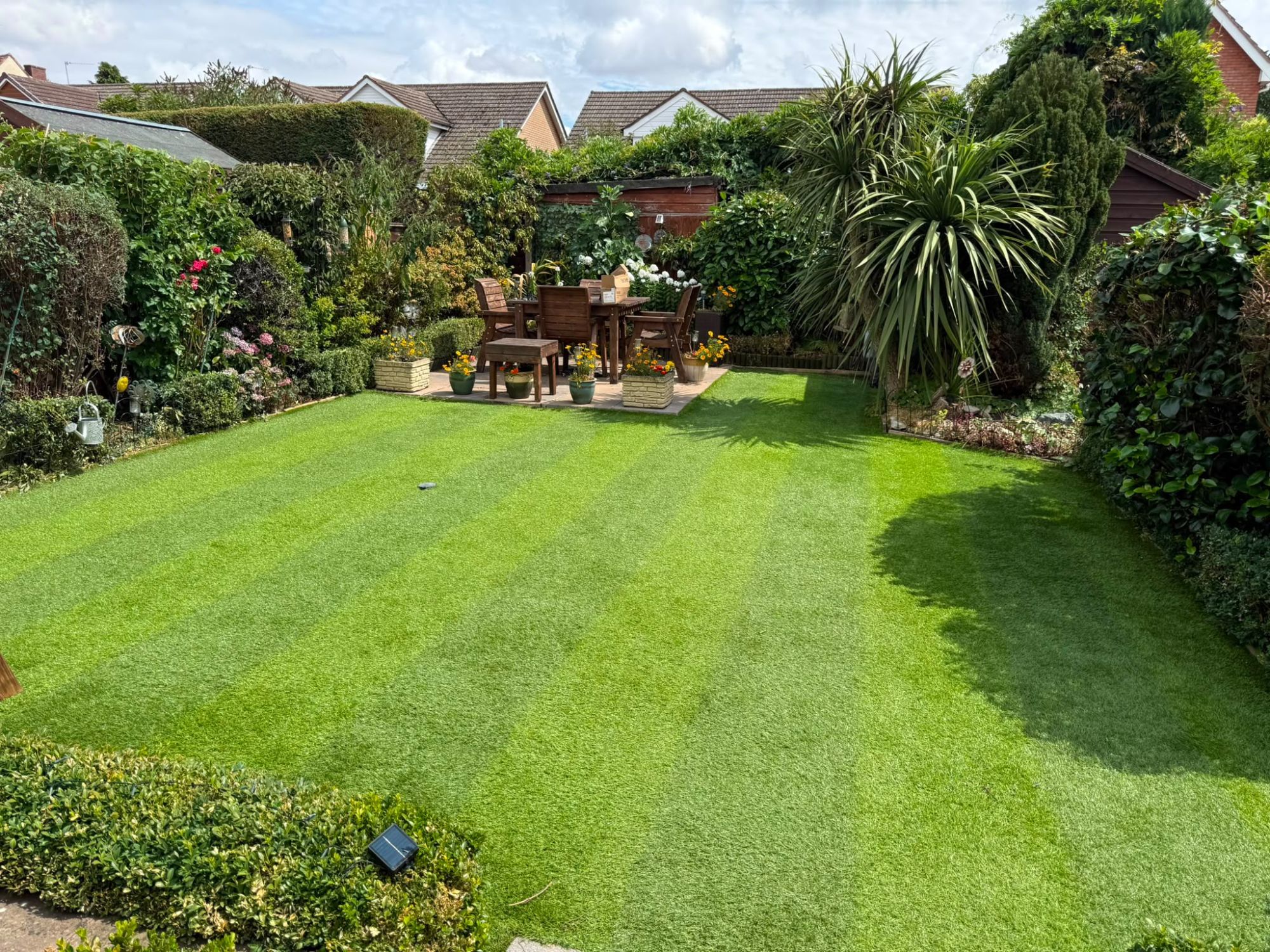 The same lawn mown to a crisp striped finish with tidy edges